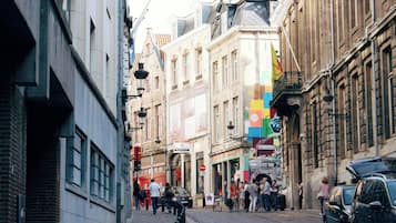 Una estrecha calle empedrada flanqueada por edificios históricos, algunos con letreros y balcones a la vista.