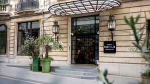 Het uiterlijk van Hotel Indigo in Brussel Stad, met een klassiek gevelontwerp, grote ramen en een opvallende entree met treden.
