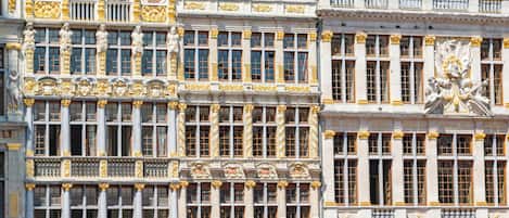 A historic building with ornate facades, large windows, and classical statues.