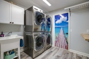 Enjoy a convenient laundry experience with a washer and dryer unit, sink, and ample storage for laundry supplies.