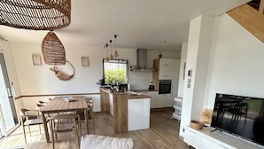 Een moderne woonruimte met een eethoek, keuken en zithoek.