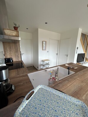 A modern kitchen with a wooden countertop, a sink, and a coffee machine. - Villa in Roscoff with heated indoor pool (Roscoff)