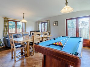 A pool table with a blue felt surface, surrounded by wooden chairs and a dining table. - 4 bedroom accommodation in Cayton, near Scarborough (Cayton, near Scarborough)