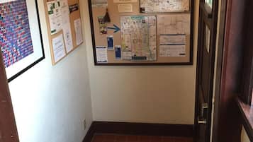 Un pasillo con un tablón de anuncios que muestra mapas e información de bienvenida.