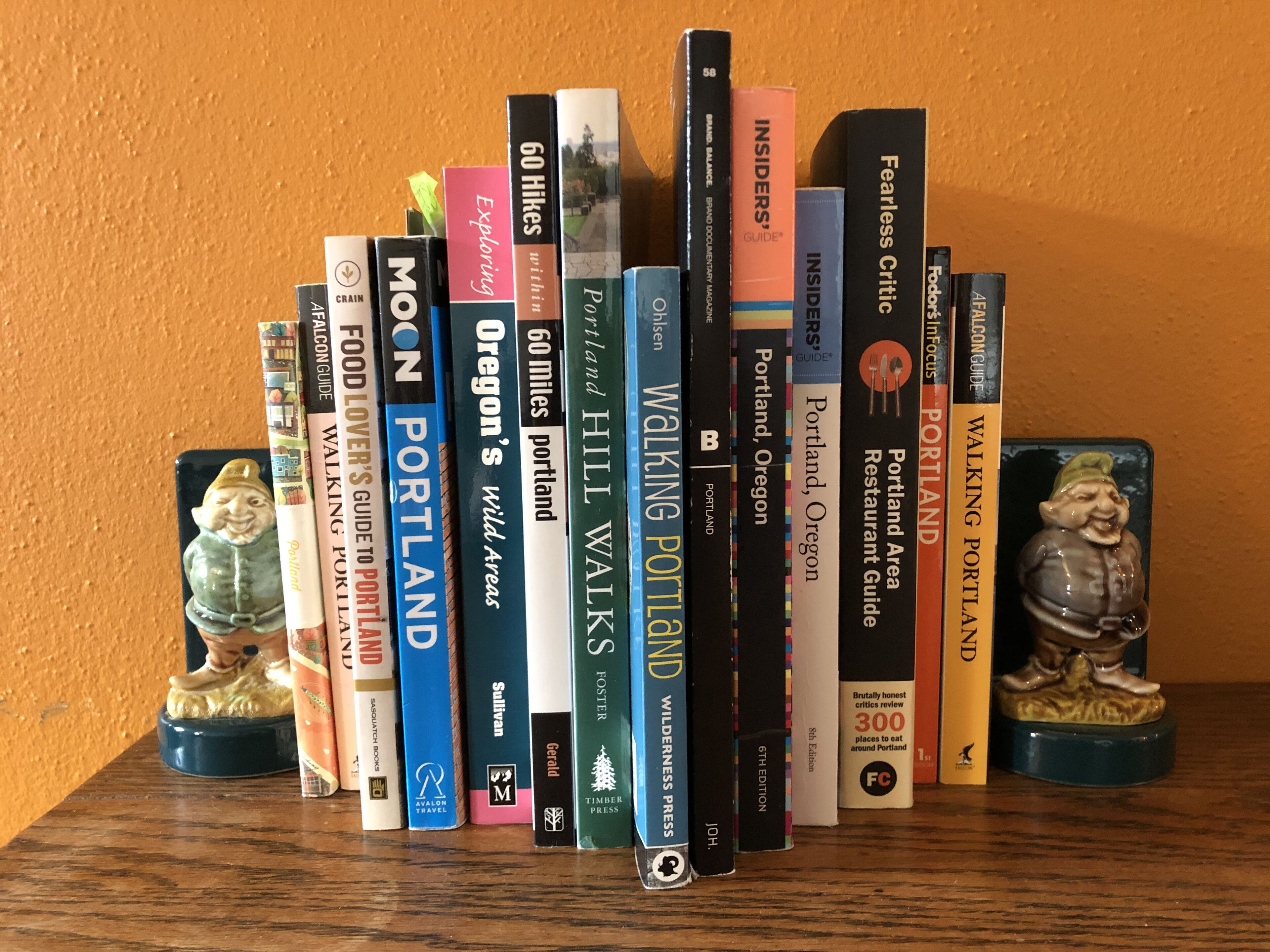 Eine Auswahl an Büchern in einem Regal, darunter Titel wie "Portland" und "Exploring Oregon's Wild Areas".