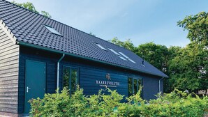 A building with a dark blue exterior, a sloped roof, and a sign that reads "HAARREVOLTIE VERZORUNG & ONSPANNING". - Beautiful apartment in Schagerbrug (Schagerbrug)