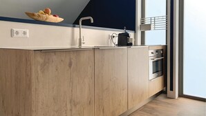 A modern kitchen with a wooden countertop, a built-in oven, and a window overlooking a balcony. - Beautiful apartment in Schagerbrug (Schagerbrug)