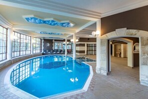 Una piscina cubierta, tumbonas