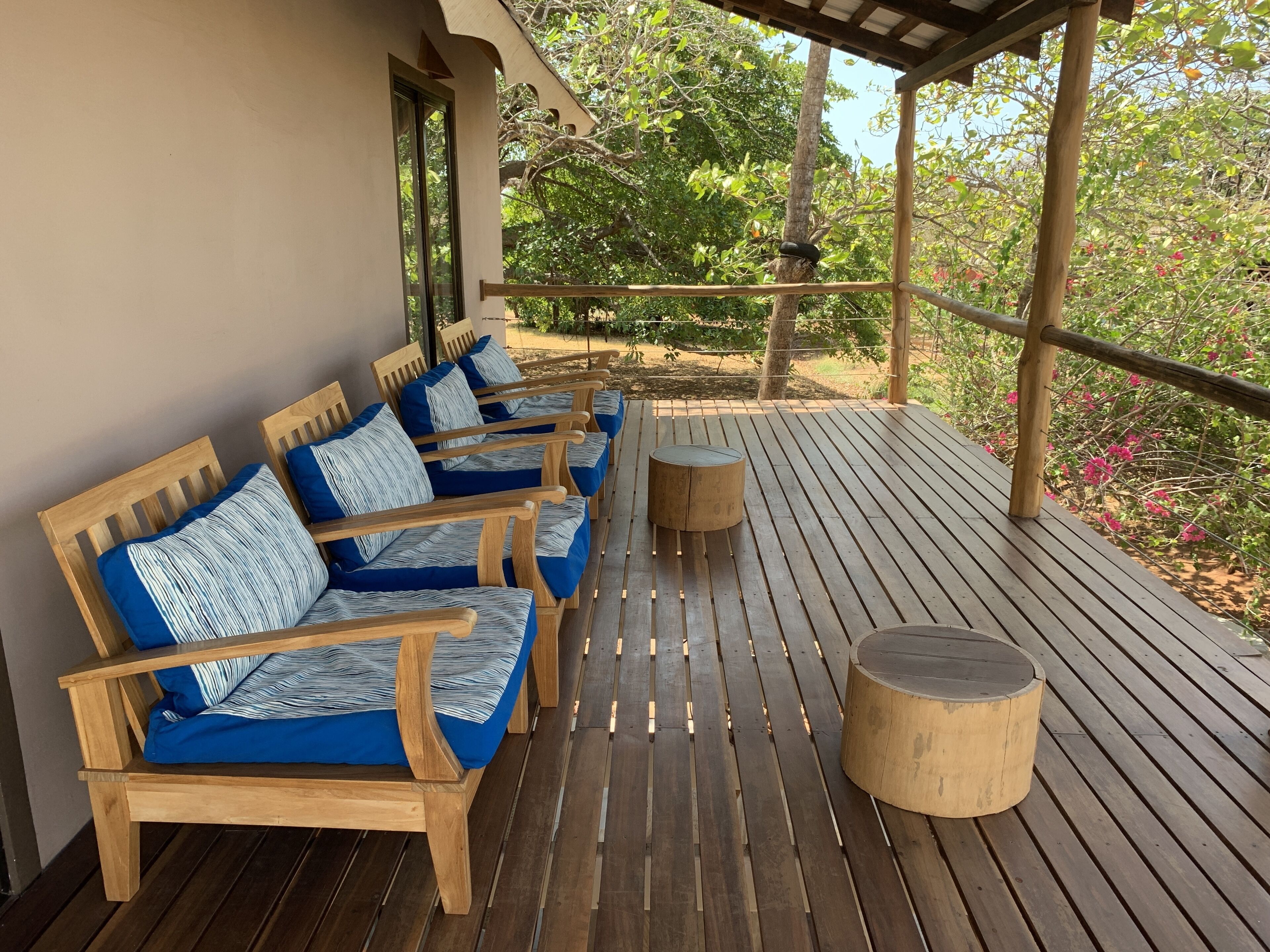 A wooden deck with a sofa set and a round table.