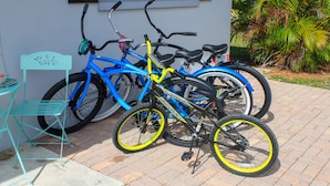 A blue bicycle with yellow accents parked next to a building. - BEACH TIME! WALK/BIKE TO THE BEACH-Min to shops, dining, movies-Fenced backyard (Naples)