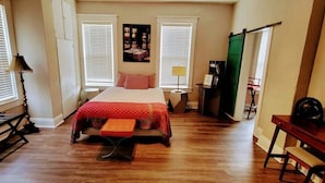 A bedroom with a bed, a desk, a chair, a lamp, and a window. - Pet and kid friendly duplex with 2 bedrooms (Pacific)