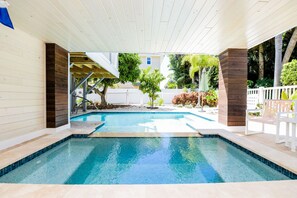 A swimming pool with a wooden deck and a covered area. - Gulf View Retreat! Pool, Decks and 2 King Beds! (Anna Maria)