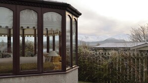 Ein Wintergarten mit Blick auf schneebedeckte Berge.