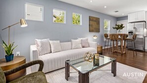 Una sala de estar moderna con un sofá, una mesa de centro y un comedor con sillas.