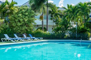 Una piscina al aire libre, sombrillas