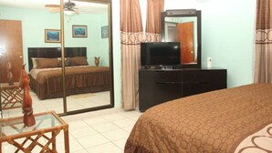 A hotel room with a bed, a television, a dresser, and a mirror. - My little paradise on earth.  (Chicxulub, Progreso, Yucatán)