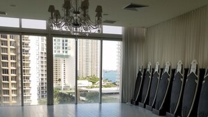 A spacious room with large windows, a chandelier, and yoga mats arranged on the floor. - Fun Getaway in the Center of Downtown Miami , available for art Basel (Miami)