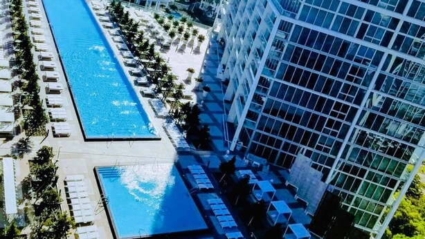 A high-rise hotel with a large swimming pool and sun loungers. - Fun Getaway in the Center of Downtown Miami , available for art Basel (Miami)