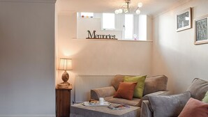 A cozy living room with a sofa, ottoman, and a lamp. - 3 bedroom accommodation in Giggleswick, near Settle (Giggleswick, near Settle)
