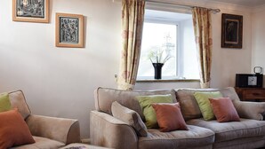 A living room with two sofas, a coffee table, and a window with curtains. - 3 bedroom accommodation in Giggleswick, near Settle (Giggleswick, near Settle)
