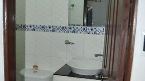 A small bathroom with a toilet, sink, and cabinet. - Las Margaritas (Cali)