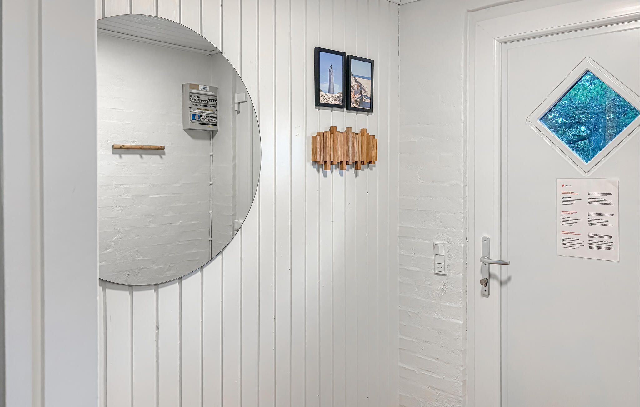 Une porte blanche avec une petite fenêtre, un interrupteur fixé au mur et une poignée de porte.