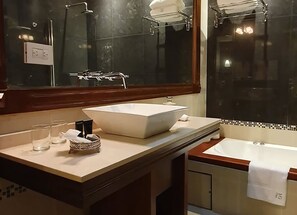 A bathroom with a large mirror, a vessel sink, a towel rack, and a glass cabinet. - MG Design Hotel Boutique - Adults Only (Salta)