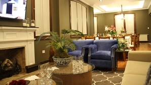 Una sala de estar moderna con chimenea, televisor y comedor con candelabro.