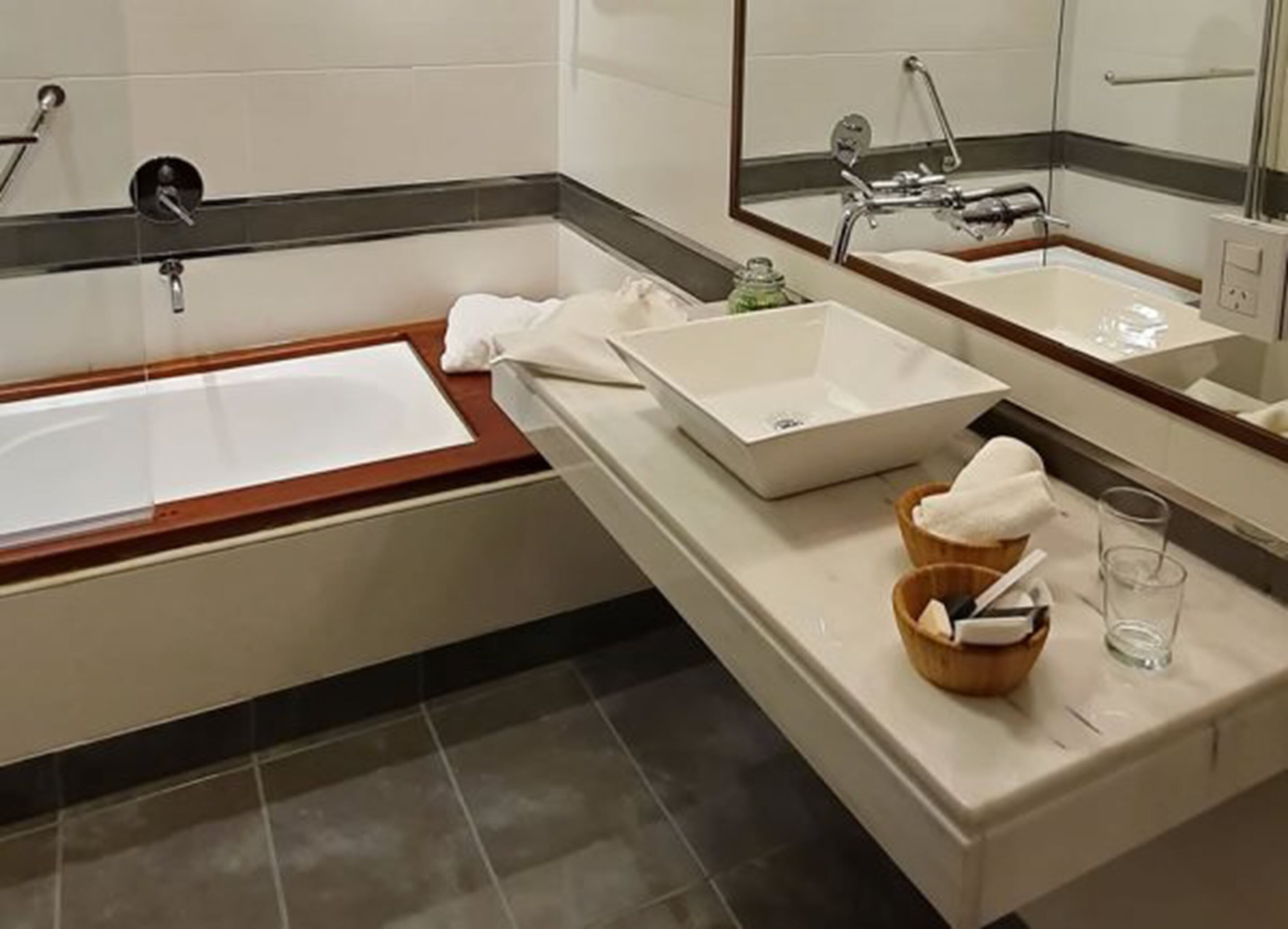 Et moderne badeværelse med et stort badekar, en håndvask og et spejl.
