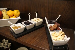 Un bufé con diversas opciones de comida, incluyendo frutas, frutos secos y otros bocadillos.