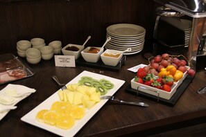 Un bufé con varias frutas y aderezos.