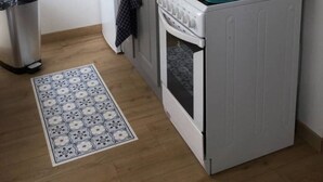 A compact kitchen with a microwave, toaster, and stove, a trash bin, and a patterned rug. - SWEET HOME GOLF OF APREMONT (Apremont)