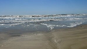 A beach with waves and a clear sky. - Toes In The Sand Drink In My Hand (Freeport)