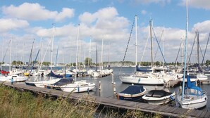 A marina with numerous sailboats docked at wooden piers.