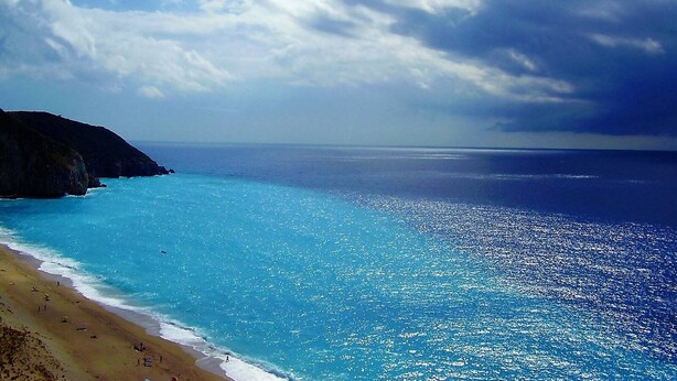 Paisagem costeira com uma praia e falésias.