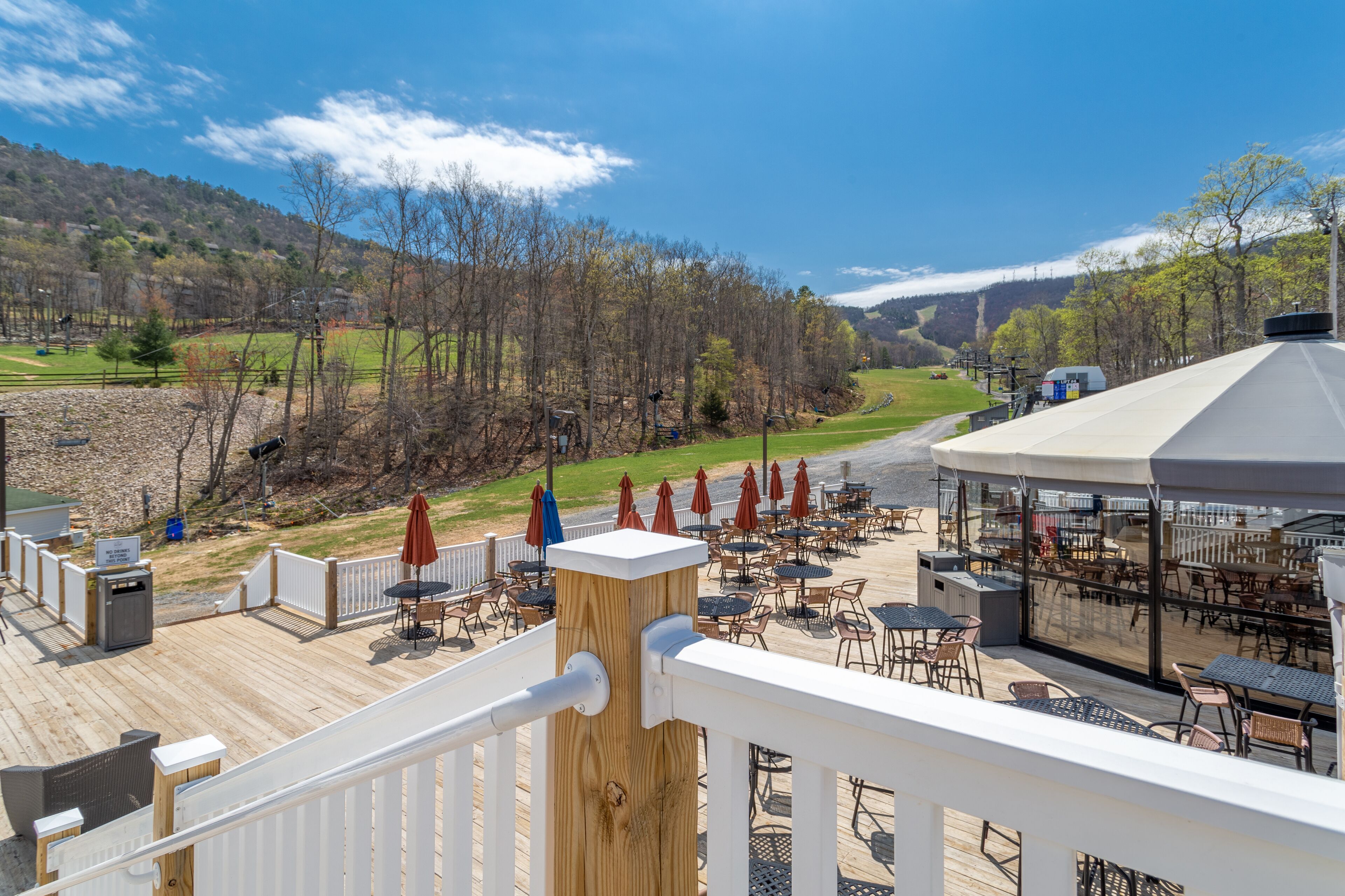 Une terrasse avec coin salon extérieur, un belvédère et une vue sur un terrain de golf.