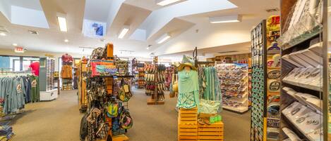 A spacious retail store with wide aisles, various clothing and accessories on display, and a high ceiling with skylights.