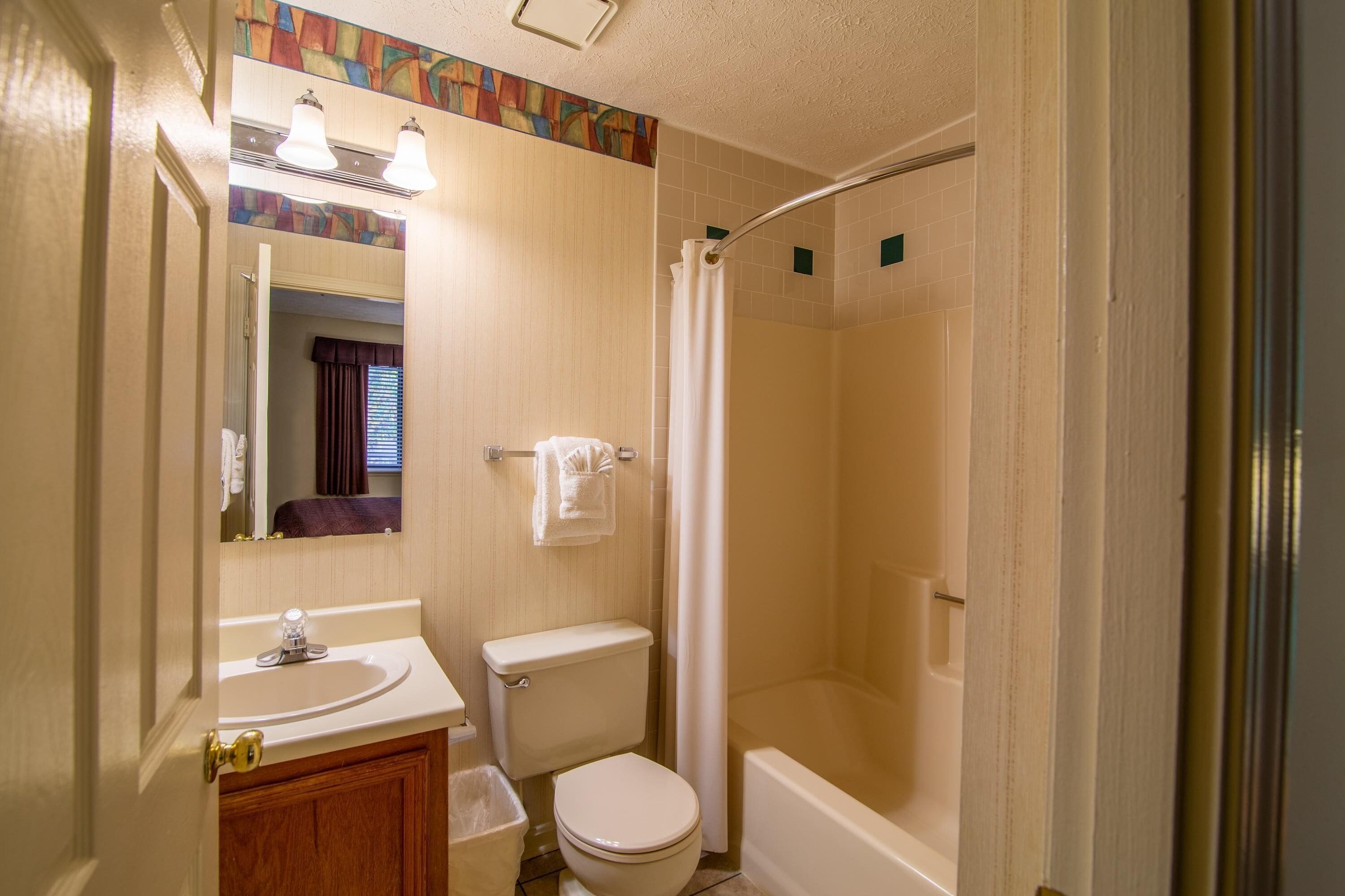 Een badkamer met een wastafel, toilet en douche.