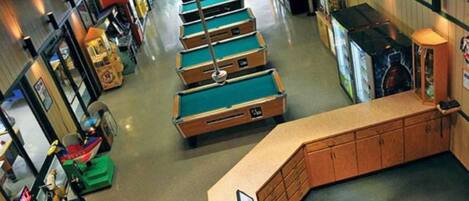 A pool table area with multiple tables, a counter, and various gaming machines.