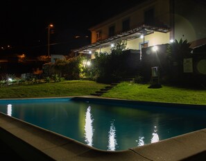 Vista frontal de la propiedad por la tarde o noche
