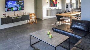 A modern living room with a sofa, a coffee table, and a TV mounted on the wall. - Amazing home in Grenaa with WiFi (Grenaa)