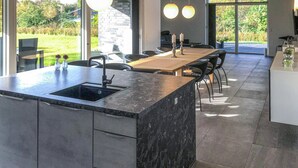 A modern kitchen with a large island, built-in appliances, and a view of the garden. - Amazing home in Grenaa with WiFi (Grenaa)