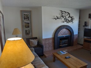 A living room with a sofa, a coffee table, a fireplace, and a lamp. - 2BR 2BA Condo short walking distance to Vail Mountain gondola, Lionshead Village (Vail)