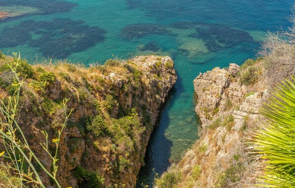 A coastal cliff with a narrow water channel.