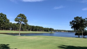 Un campo de golf con un lago y árboles.