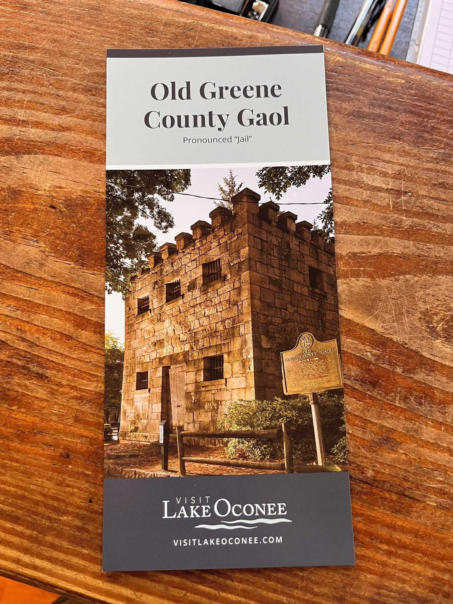 Eine Broschüre über das Old Greene County Gaol, mit einem Steinhaus, das mit Gitterfenstern und einem Schild versehen ist.