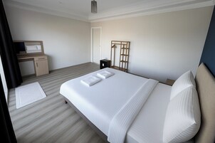Una habitación de hotel moderna con una cama grande, un escritorio y un armario.