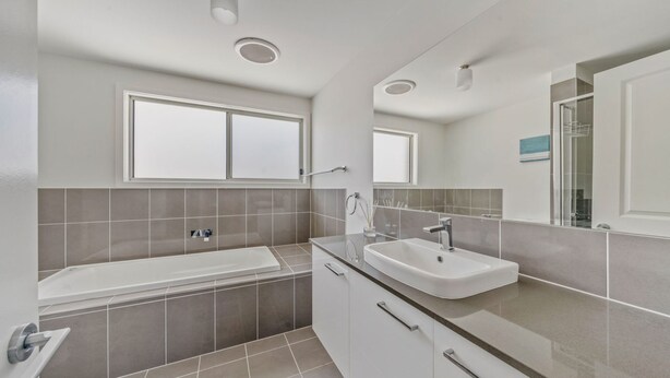 Une salle de bain moderne avec une baignoire, un lavabo et un grand miroir.