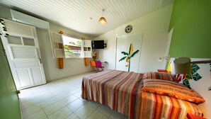 Een slaapkamer met een bed, een televisie, een raam en een deur.