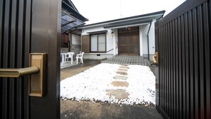 Una zona residencial con una casa, un portón y un camino pavimentado con piedras.